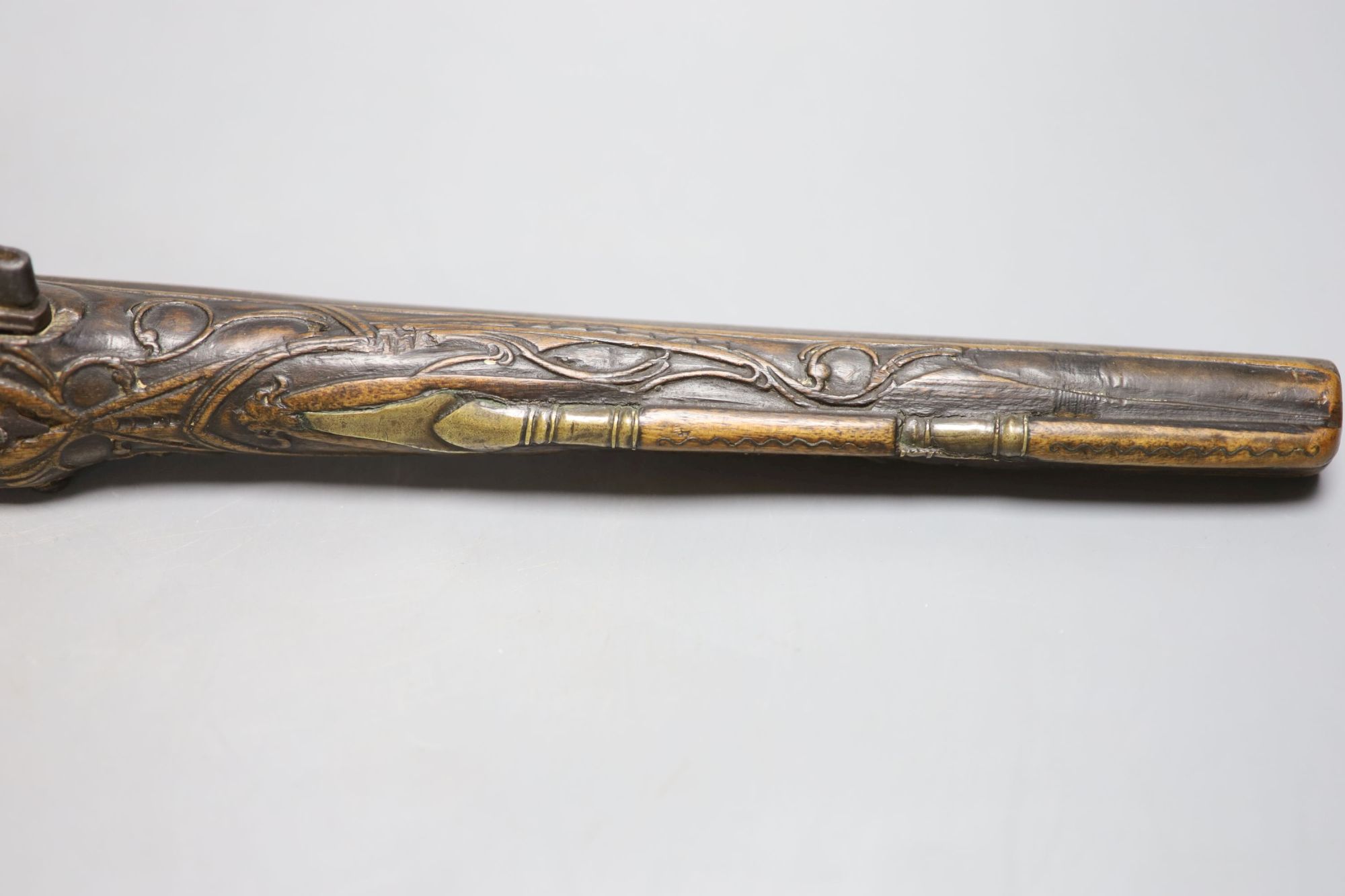 A 19th century Ottoman carved wood and brass mounted flintlock pistol, length 45cm